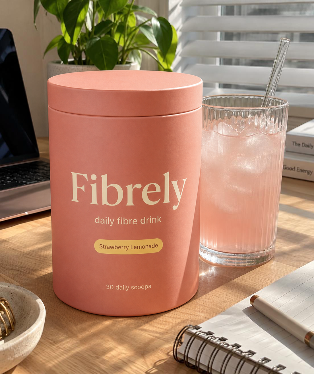 Fibrely Strawberry Lemonade and a glass on a sunlit desk